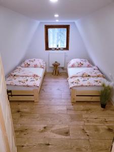 2 camas en un ático con ventana en Chata pod lesíkom, en Lazisko