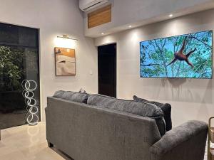 ein Wohnzimmer mit einem Sofa und einem Flachbild-TV in der Unterkunft GoldenView+ Aire acondicionado+Jacuzzi (a 15 km de Monteverde) in Monteverde Costa Rica