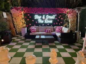 um palco com um sofá e uma placa que diz para parar e cheirar as rosas em 5 BR - Sleeps 10! Best Location next to French Quarter! em Nova Orleães