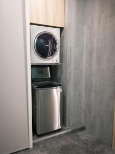 uma máquina de lavar e secar roupa num pequeno quarto em 新仕飯店-New City Hotel em Taipei