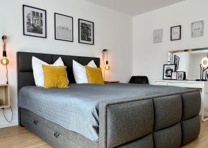 ein Schlafzimmer mit einem großen Bett mit gelben Kissen in der Unterkunft VonMos Balkon Apartment in Bernkastel-Kues