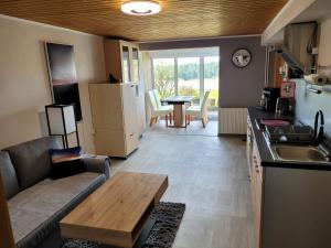 a kitchen and living room with a couch and a table at Schöne Ferienwohnung in Hilscheid Hunsrück in Hilscheid