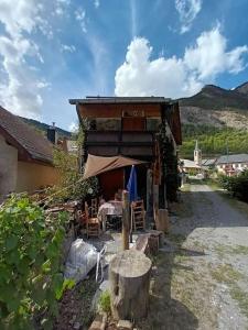 um edifício com uma mesa e cadeiras em frente em Maison de montagne 2 à 8 couchages proche Barcelonette em Condamine-Châtelard