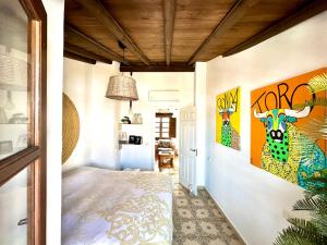 een kamer met een bed en schilderijen aan de muur bij Apartamento La Galería de Ronda in Ronda