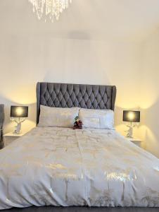 Seaesta Apartments في Macduff: غرفة نوم بسرير ابيض كبير ومصباحين