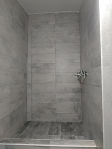 a bathroom with a shower with a tiled shower at Maison Jolie in Vlachopoulátika