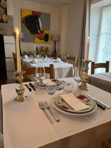 a table with a white table cloth and candles on it at Le Clos Romantic & Spa - Périgueux - Bassillac et Auberoche in Eyliac