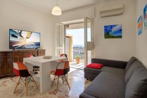 een woonkamer met een bank en een tafel en stoelen bij Top Floor Aparthotel Bentivoglio in Catania