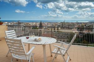 d'une table et de chaises blanches sur un balcon avec vue. dans l'établissement Top Floor Aparthotel Bentivoglio, à Catane