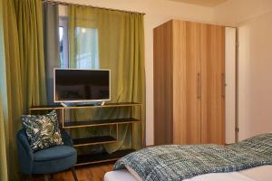 a bedroom with a bed and a tv and a chair at Beachvilla Velden in Velden am Wörthersee