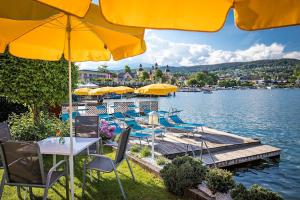 a group of tables and chairs with umbrellas on a dock at Beachvilla Velden in Velden am Wörthersee