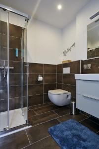 a bathroom with a toilet and a glass shower at Beachvilla Velden in Velden am Wörthersee