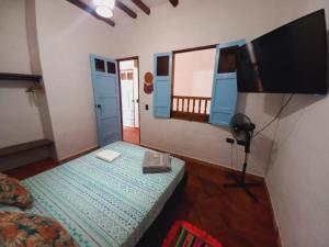 ein Wohnzimmer mit einem Flachbild-TV und einem Bett in der Unterkunft Casa Hostal Colonial VaraEchada in Barichara