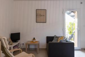 uma sala de estar com um sofá e uma televisão em Les Lauriers d'Aimée pour 4 pers em Mirabel-et-Blacons
