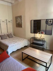 een slaapkamer met 2 bedden en een salontafel bij AU CENTRE DU FESTIVAL in Avignon