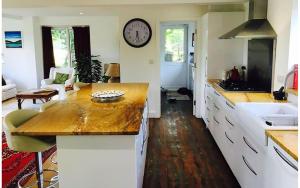 a kitchen with a counter and a clock on the wall at A House in the Woods in Chiddingly