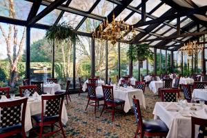 um restaurante com mesas e cadeiras brancas e um lustre em Dan'l Webster Inn and Spa em Sandwich