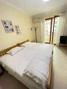 - une chambre avec un grand lit et des draps blancs dans l'établissement SkyBase, à Tirana