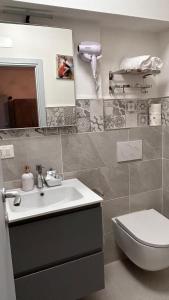 bagno con lavandino, servizi igienici e specchio di Dolce Dormire a Castiglione del Lago