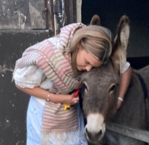 una joven abrazando a una vaca con su cabeza en Southfields Farm en Nottingham