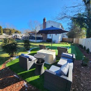 a patio with a table and chairs and an umbrella at Paradise Citadel in Mastic