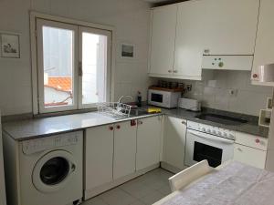 - une cuisine avec des placards blancs, un lave-linge et un évier dans l'établissement Apartamento en pleno Centro CATEDRAL, à Oviedo
