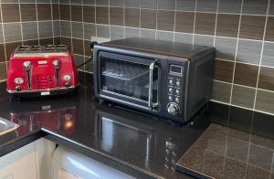 eine Mikrowelle auf einer Küchentheke mit einem Toaster in der Unterkunft Corton Villas in Lowestoft
