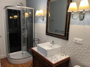 a bathroom with a sink and a shower at La BOCQUILLONNE 