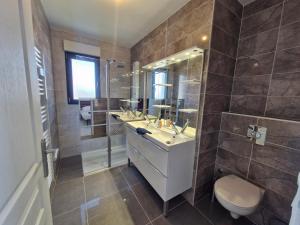 uma casa de banho com um lavatório, um WC e um espelho. em La Villa Caennaise-Caen em Caen