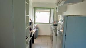 eine Küche mit einem Kühlschrank und einem Fenster in der Unterkunft Gîte 3 pièces dans Mas Catalan proche centre ville in Perpignan