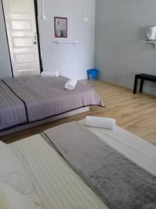 a bedroom with two beds and a rug on the floor at Tamu Chalet in Kuantan
