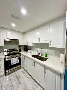 ブランプトンにあるSUITE A 2 Bedroom Apartmentの白いキャビネットとシンクのあるキッチン