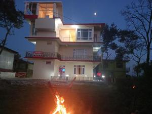 a house with a fire in front of it at night at RIGVEDA Bir Billing in Bīr