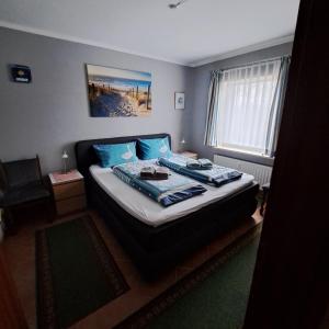 a bedroom with a bed with blue pillows at Apartment Wiesener in Büsum