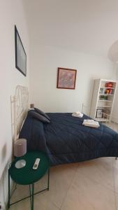 - une chambre avec un lit bleu et une table verte dans l'établissement Casa Publicola, à Rome