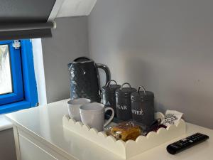 倫敦的住宿－Wembley Serviced Apartment, 20mins from Central London，厨房柜台,上面有杯子和其他物品