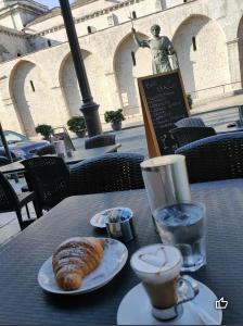 - une table avec un plateau de croissants et une tasse d'eau dans l'établissement Casa San Giacomo, à Barletta