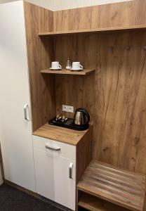 a small kitchen with wooden walls and a stove at Penzión Aira in Zvolen