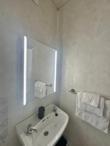 a white bathroom with a sink and a mirror at Crega Cottage in Malin Head