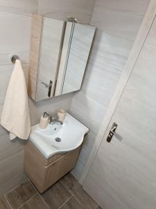 La salle de bains est pourvue d'un lavabo et d'un miroir. dans l'établissement Oli's Sea House, à Salamine