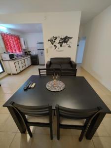 una mesa negra y sillas en la sala de estar. en Dpto Nuevocentro Shopping en Córdoba