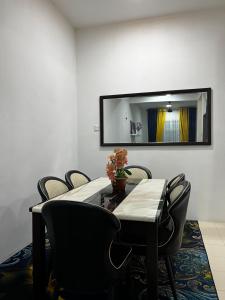 a dining room table with chairs and a mirror at Amaris Homestay in Sungai Petani