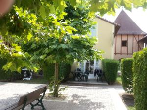 a tree in the courtyard of a house at Appart 1 chb lit double dans jolie résidence du Lac in Monflanquin