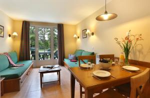 uma sala de estar com uma mesa e um sofá em Appart 1 chb lit double dans jolie résidence du Lac em Monflanquin