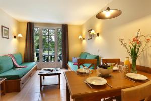 uma sala de estar com uma mesa e um sofá em Appart 1 chb lit double dans jolie résidence du Lac em Monflanquin
