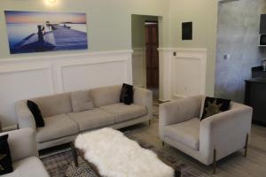 杜篤瑪的住宿－ISN Luxury Apartments，客厅配有沙发和两把椅子