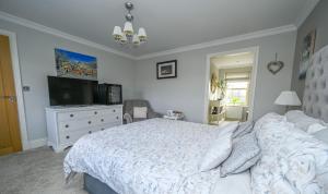 a bedroom with a bed and a flat screen tv at Sunset View at The Dovecote in Kirkby on Bain