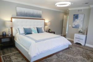 a bedroom with a large white bed with blue pillows at Disneyland Paradise 6 BedRoom 4 Bathroom Pool Spa Games in Anaheim