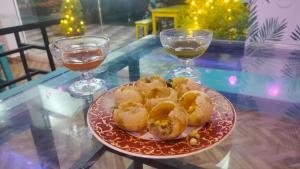 a plate of food on a table with two glasses of wine at Banyan Tree Samudra in Kovalam