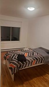 een slaapkamer met een bed en een raam bij Confort in Montreal